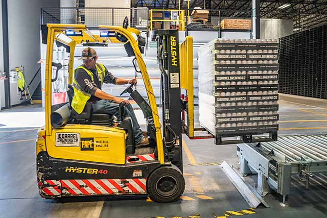 A person driving a forklift in a warehouse