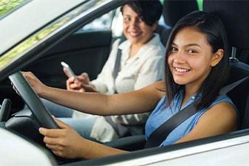 a teen driver and their parent inside of a car